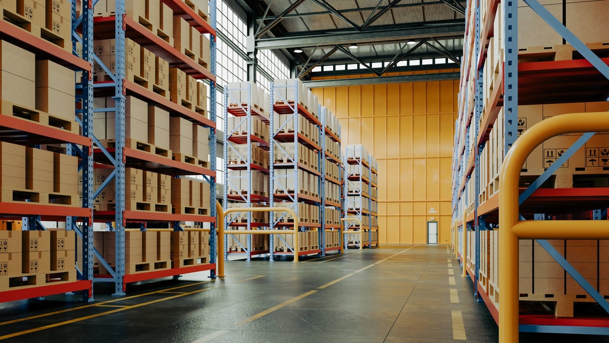Large industrial warehouse interior with high shelves full of cardboard boxes and pallets