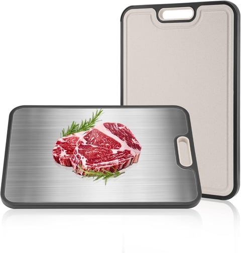 Two cutting boards with handles showing raw red meat and fresh rosemary on a metallic surface