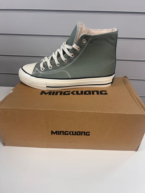 Green high-top sneaker with white laces displayed on a Mingguang cardboard box