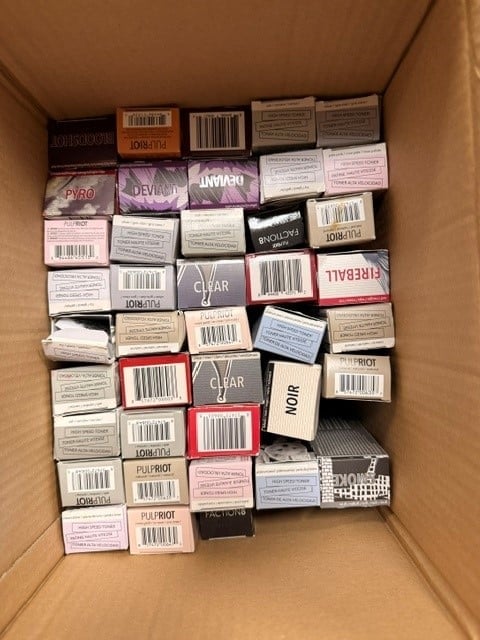 Cardboard box filled with neatly organized cosmetic products and skincare items with various brand labels and barcodes