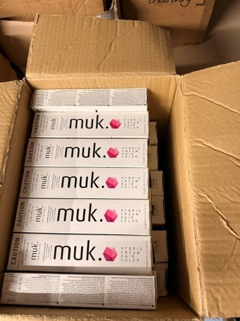 Five boxes of muk. hair color products stacked in a cardboard shipping box