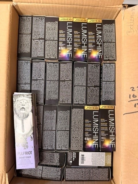 Cardboard box containing multiple Joico Lumishine hair color boxes and a purple Pulp Riot violet toner bottle